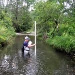 A biologist measures stream depth on a tributary of the Battenkill River.