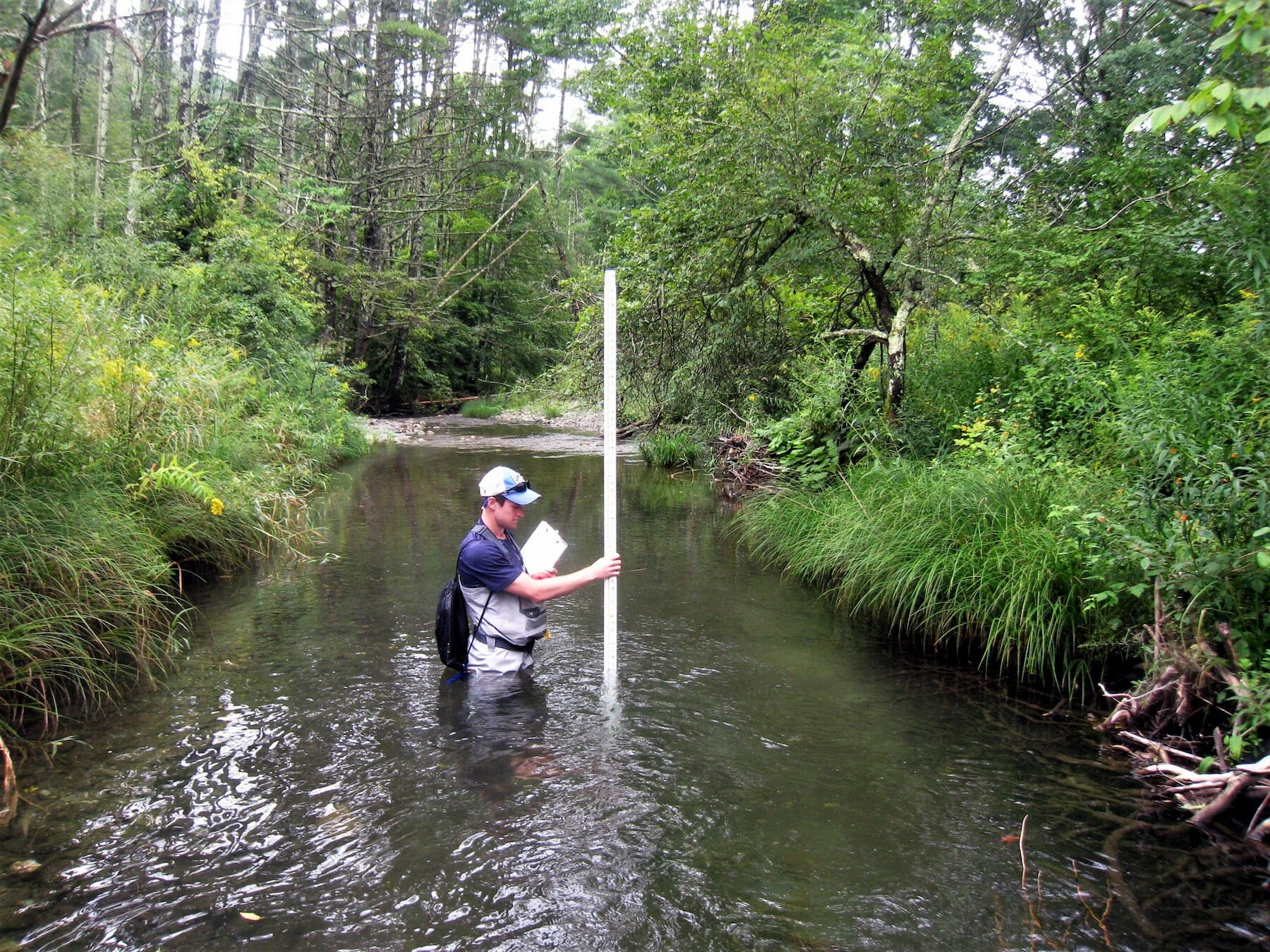 A biologist measures stream depth on a tributary of the Battenkill River.
