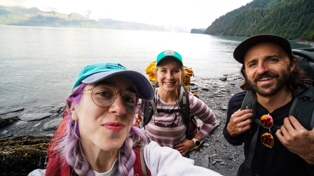 A selfie of three hikers on the shores of Resurrection Bay.