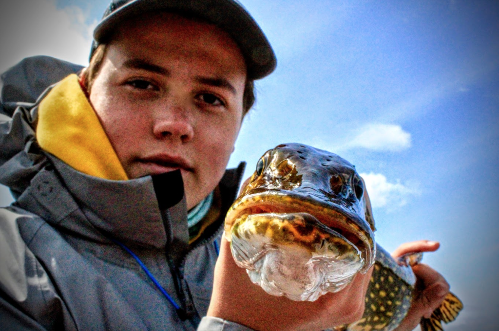 A young angler holds his first pike.