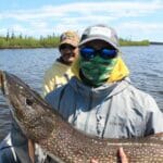 A boy holds a big northern pike.