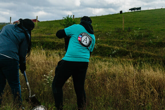 A group of people standing on top of a grass covered field

Description automatically generated