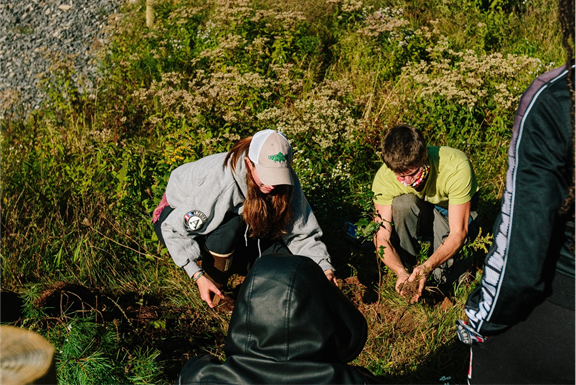 A group of people standing in a field

Description automatically generated