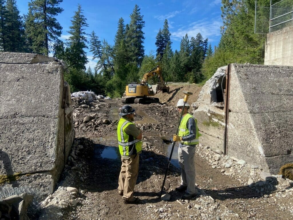 Two construction workers help remove a dam in Montana.