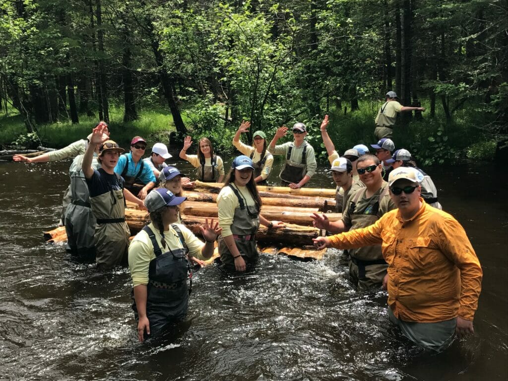Teen volunteers working in a river for Headwaters program