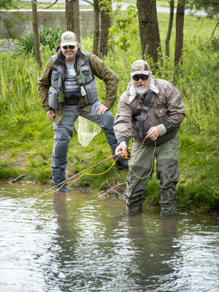 Two veterans stand in Beaver Creek casting