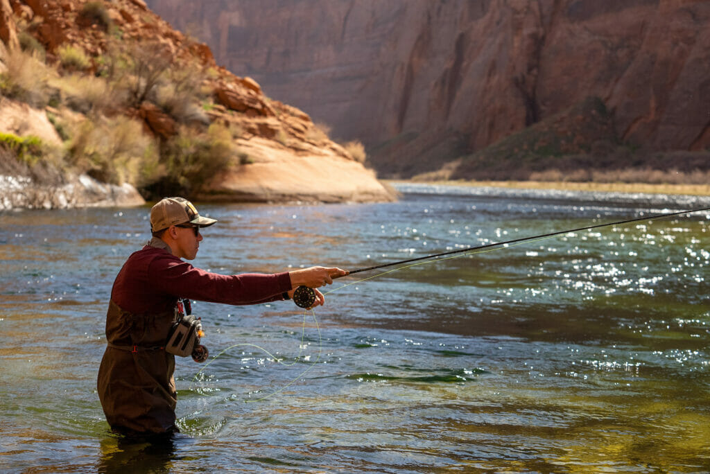 Man casting fly fish in river