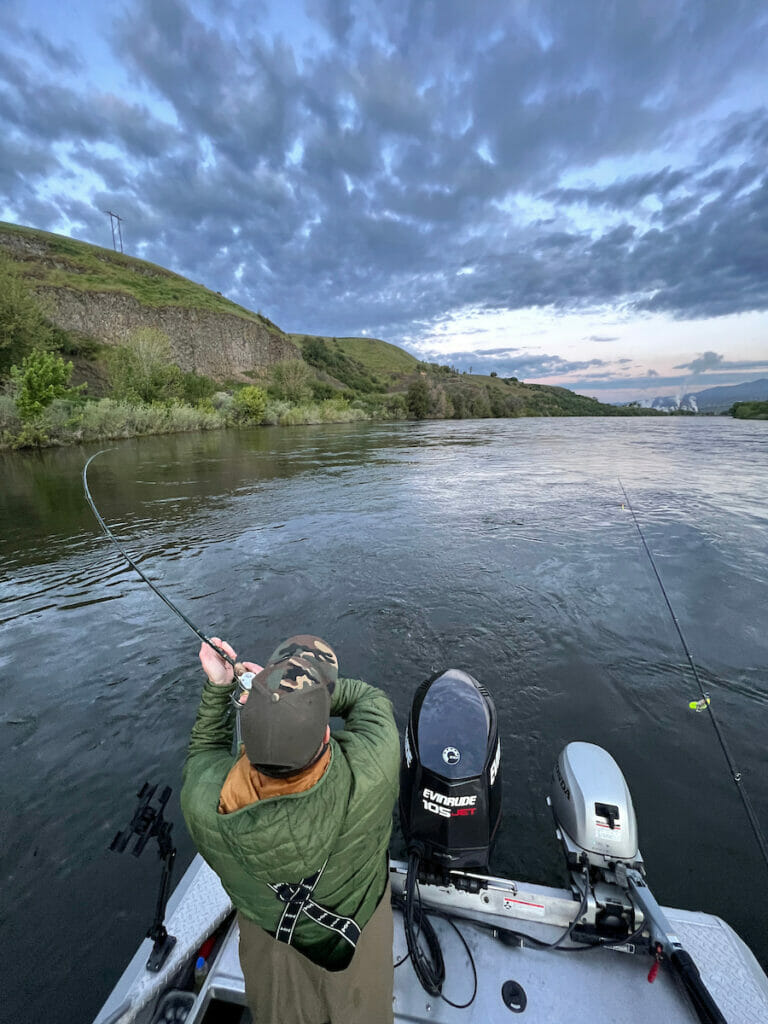 Man on power boat tris to reel in fist using a looser grip