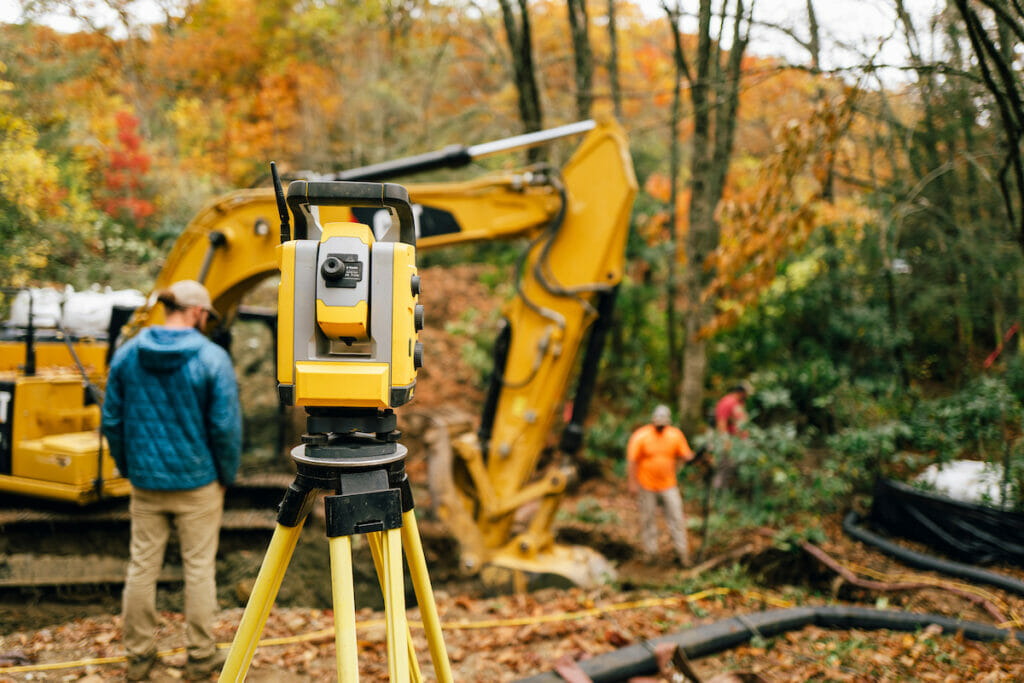 Instrument on tripod and back hoe in the woods