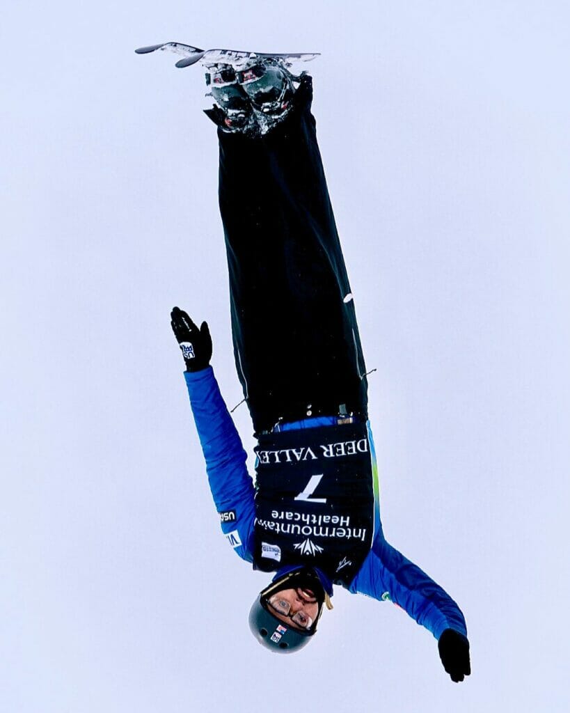 Man, upside down in the middle of a ski jump