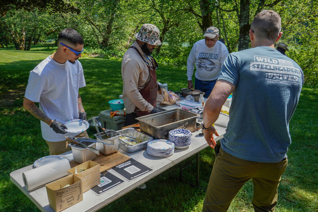 Five men get lunch from outdoor buffet table