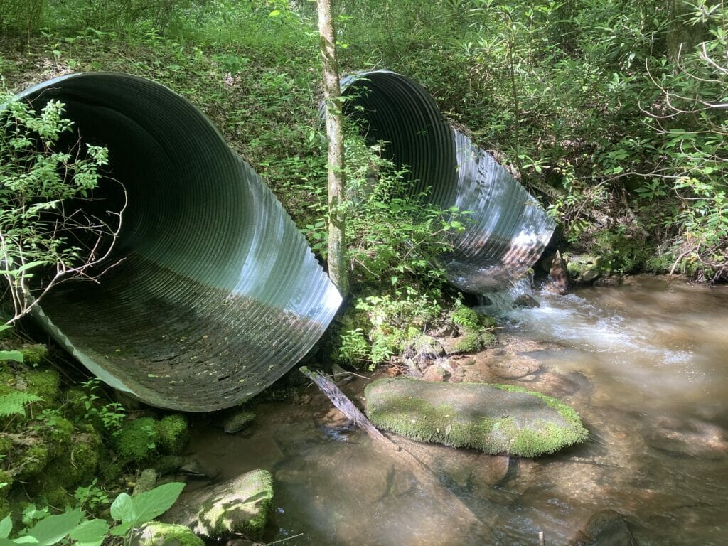 Two culverts side by side, one with water traveling through