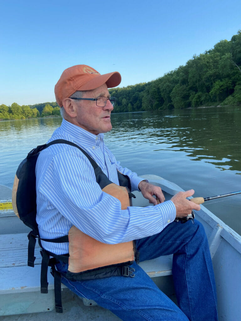 Jim Risch sits in boat holding a rod