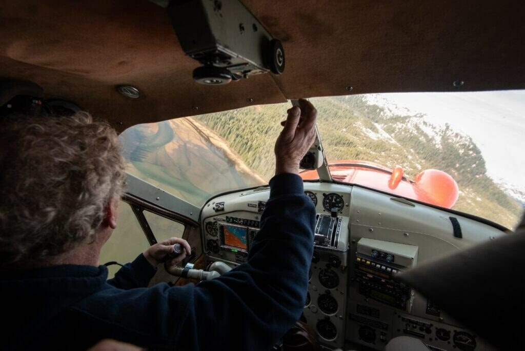 View from behind pilot, looking over the water and evergreen trees