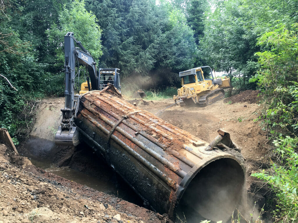 Backhoe handling a culvert