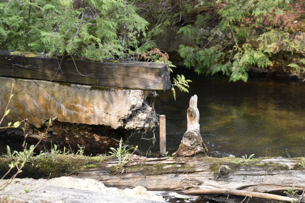 Lumber and crumbling concrete next to a river