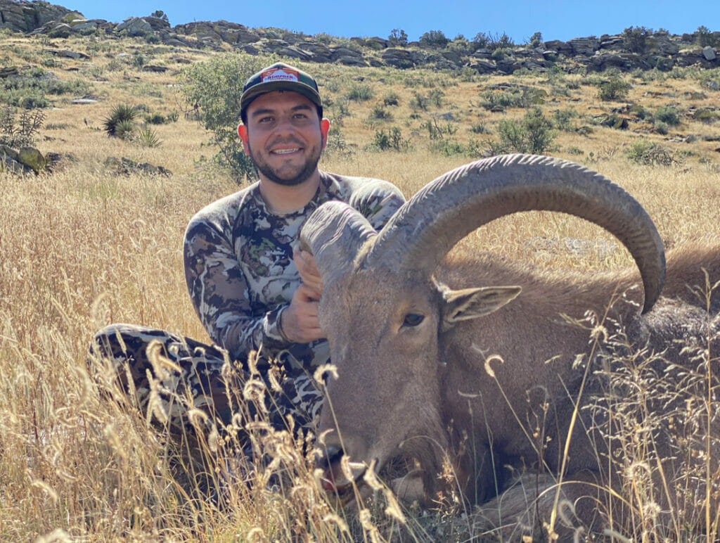 A man sits next to a dead animal, thanks to this protected national monument