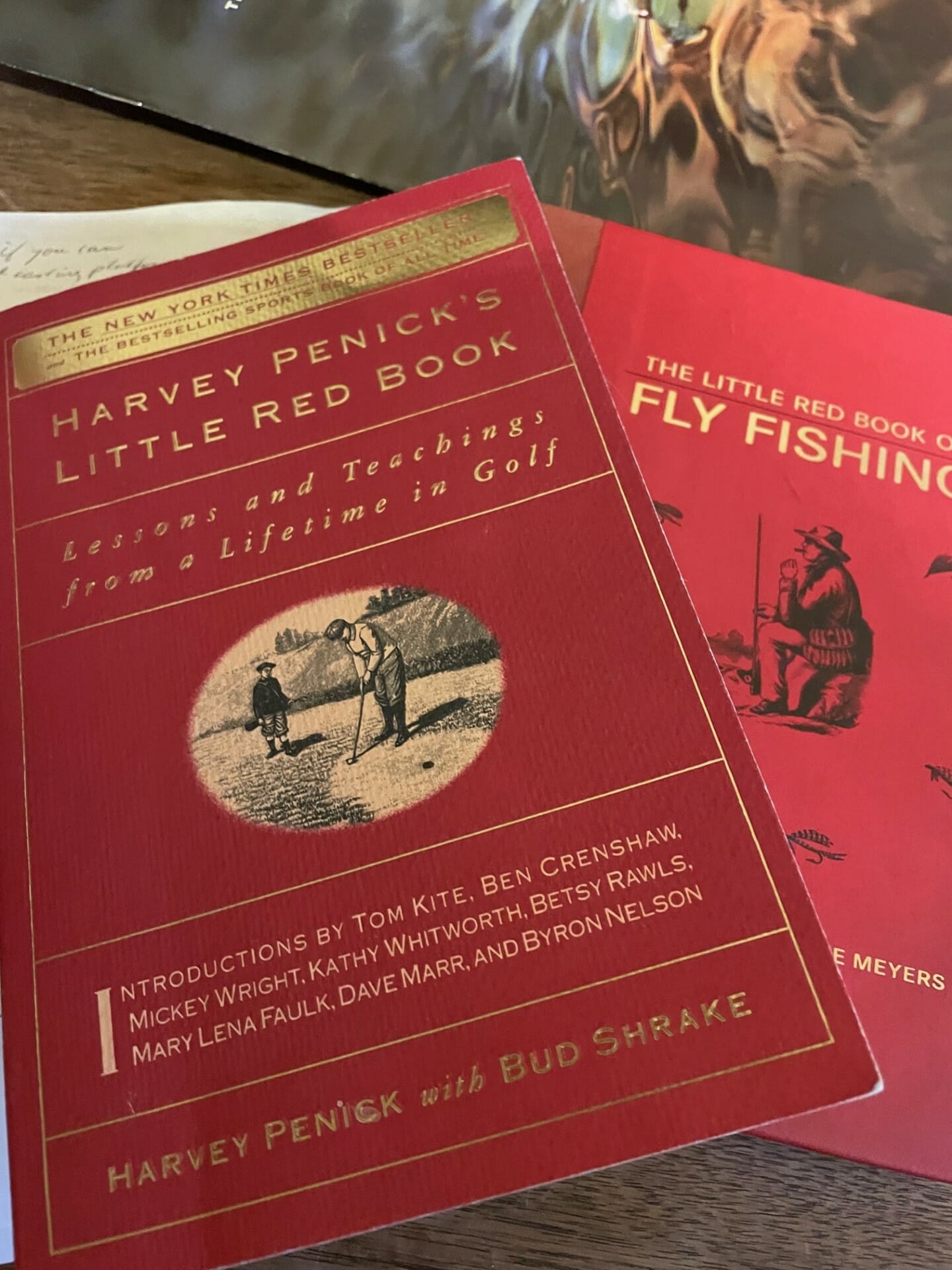 The red covers of two books about golf and fly fishing