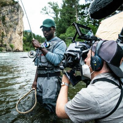Camera man shoots actor with rod and net in a river