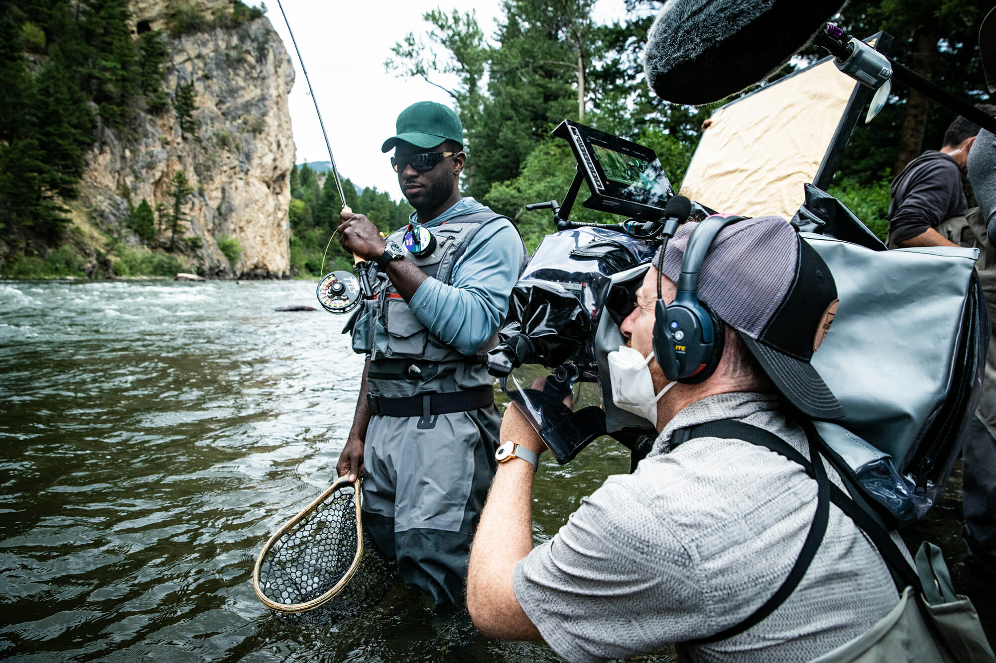 Camera man shoots actor with rod and net in a river