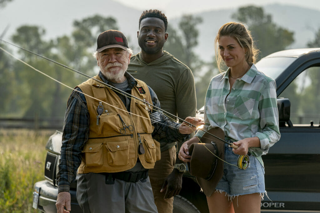 Three actors from the movie, Mending The Line, stand in front of a truck