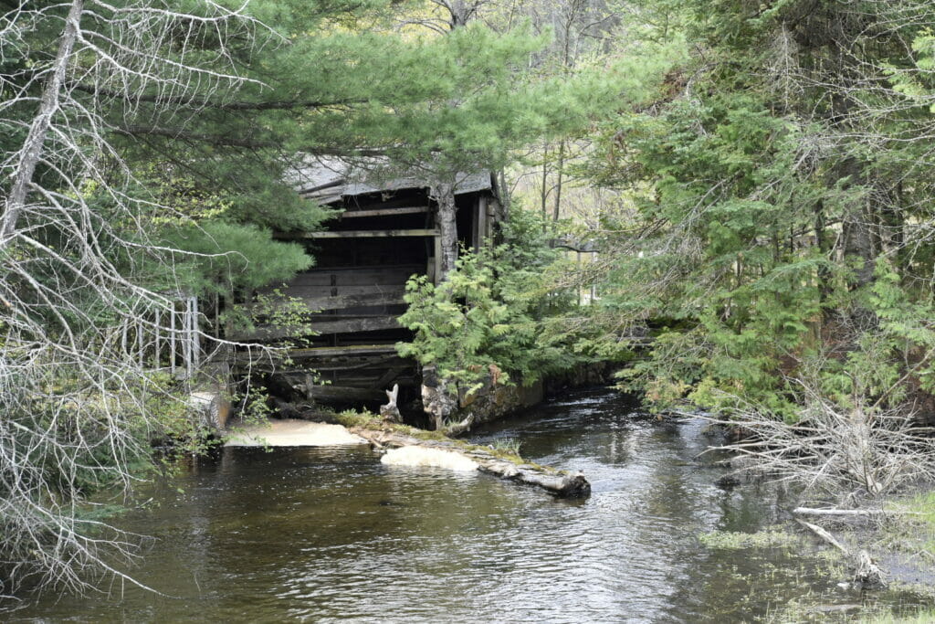 An abandoned structure falls apart next to a river