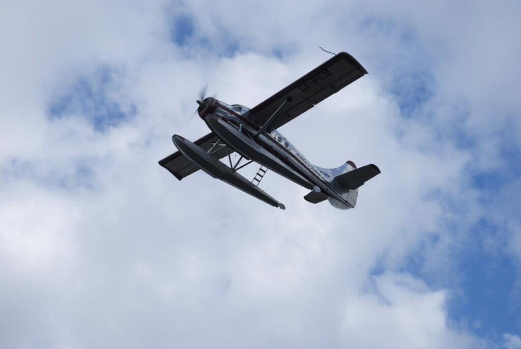 A seaplane flies among clouds