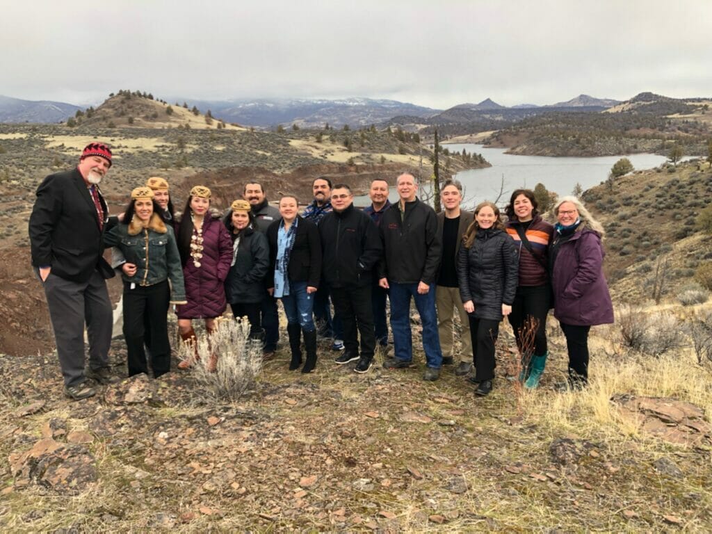 A classy group of people stand in front of a river