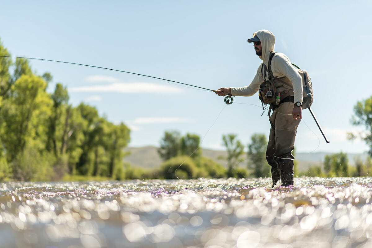 Person in hoodie fishing, shot taken at nearly water level