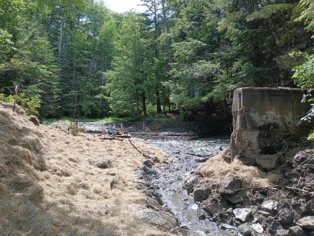 New water rushes past a dam removal  wall