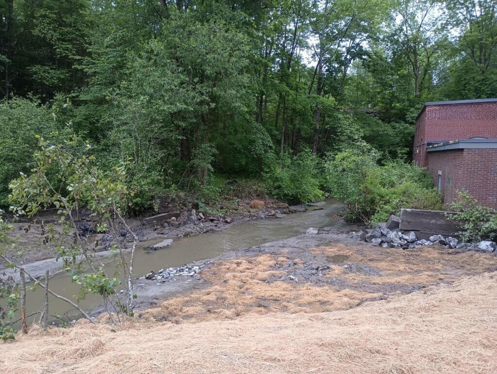 Brick building next to a muddy stream