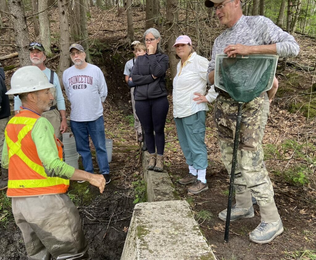 Several people get lectured in the woods by a man with in hard har