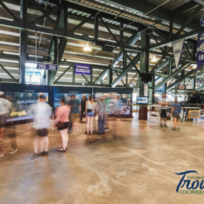 People looking at three vary large video screens showing Trout Unlimited promotional images