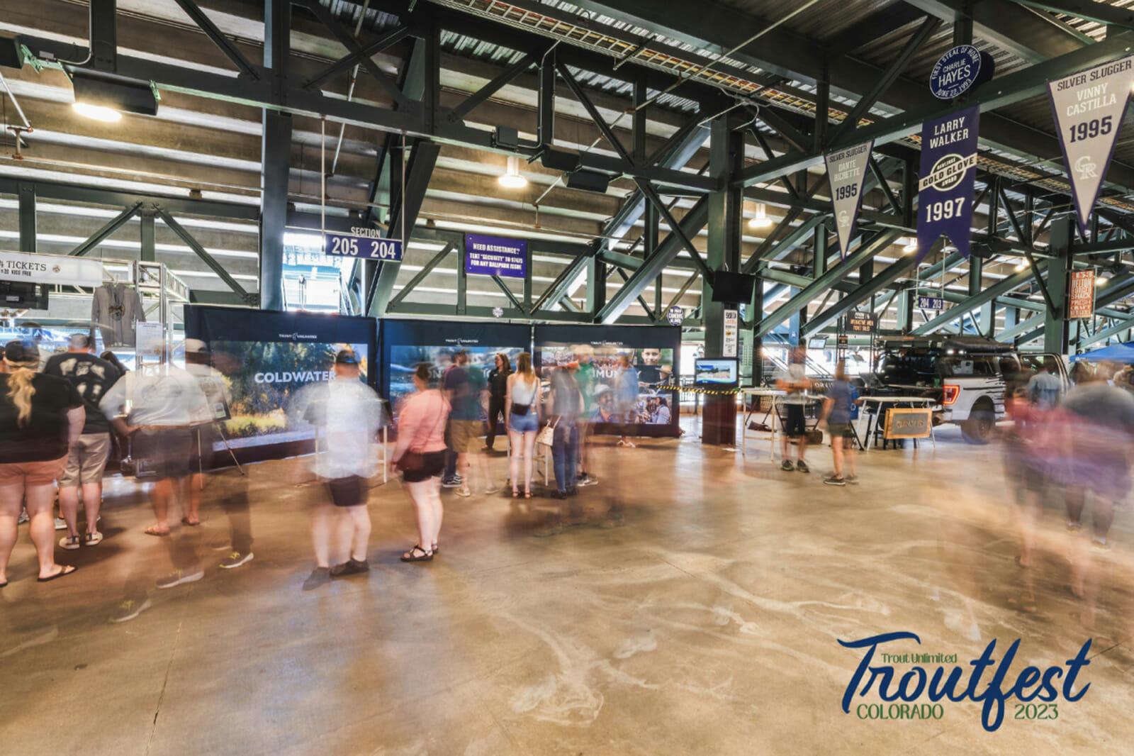 People looking at three vary large video screens showing Trout Unlimited promotional images