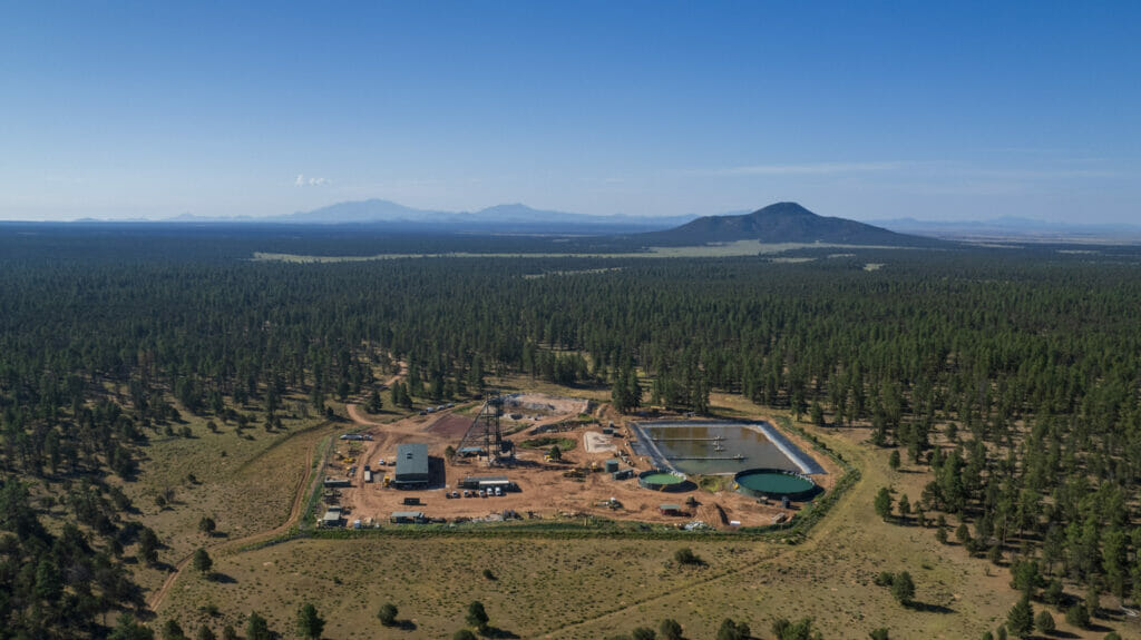 Areal view of a mining operation surrounded by forrest and mountains