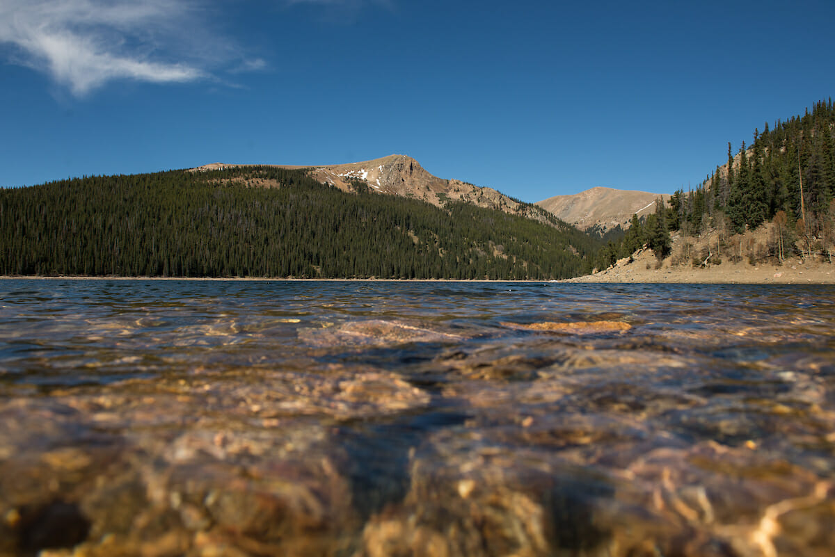 Close up of water in a lake with mountains in the background