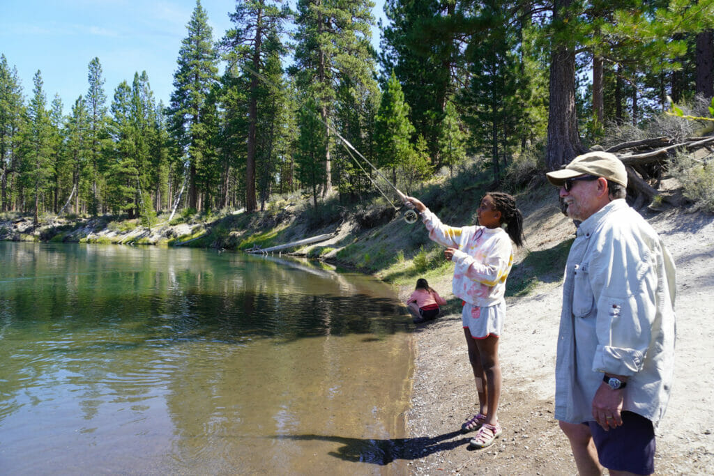 Man watches a young girl fish