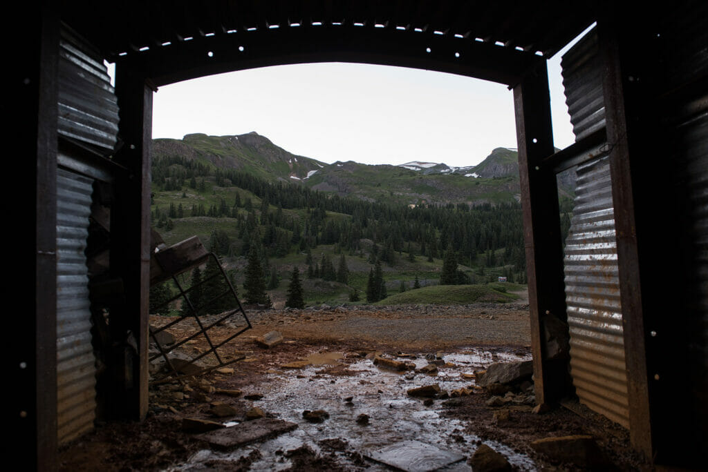 Discolored water coming out of a mine opening, viewed from inside abandoned mines