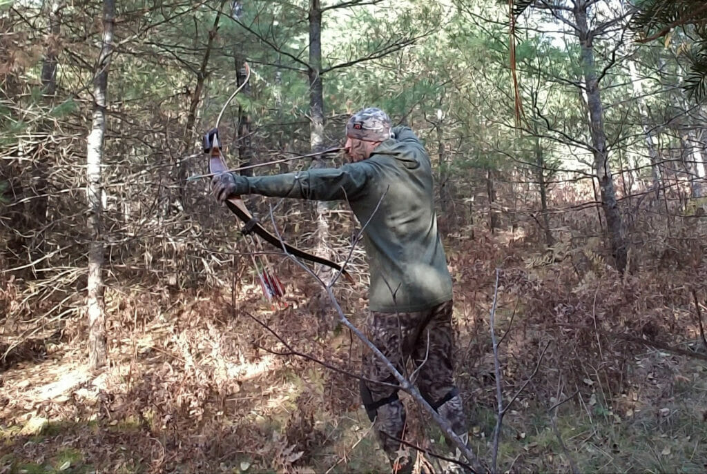 Man in the woods bowhunting
