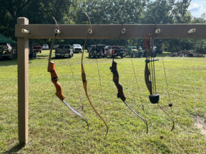 An outdoor rack holding four archery bows