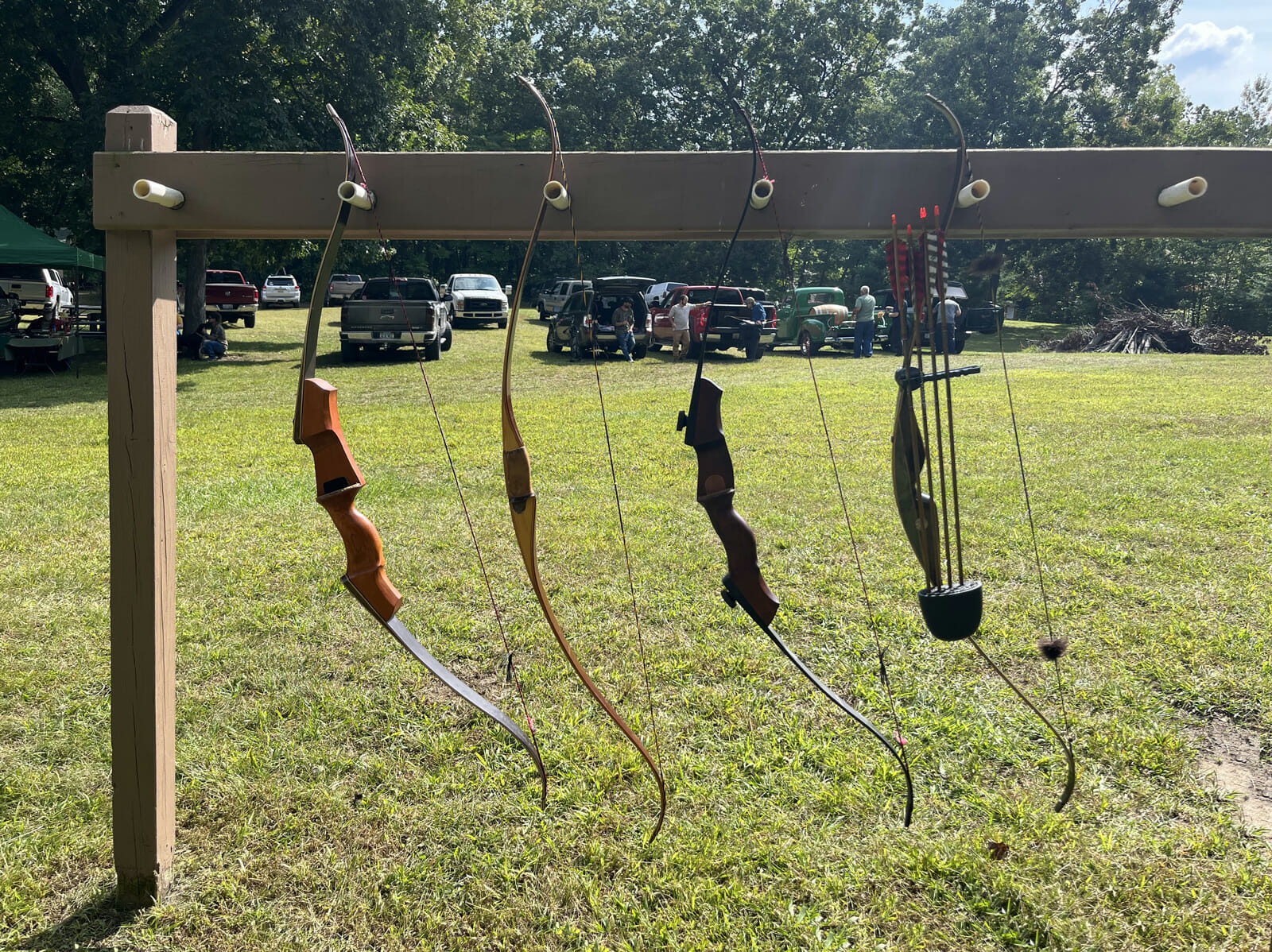 An outdoor rack holding four archery bows