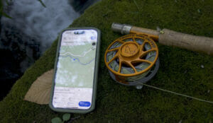 A fishing ole and a smart phone that shows a map of Iron Ore Knob