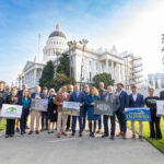 A group of supporters of AB 1624 stands in front of the California State Capitol.