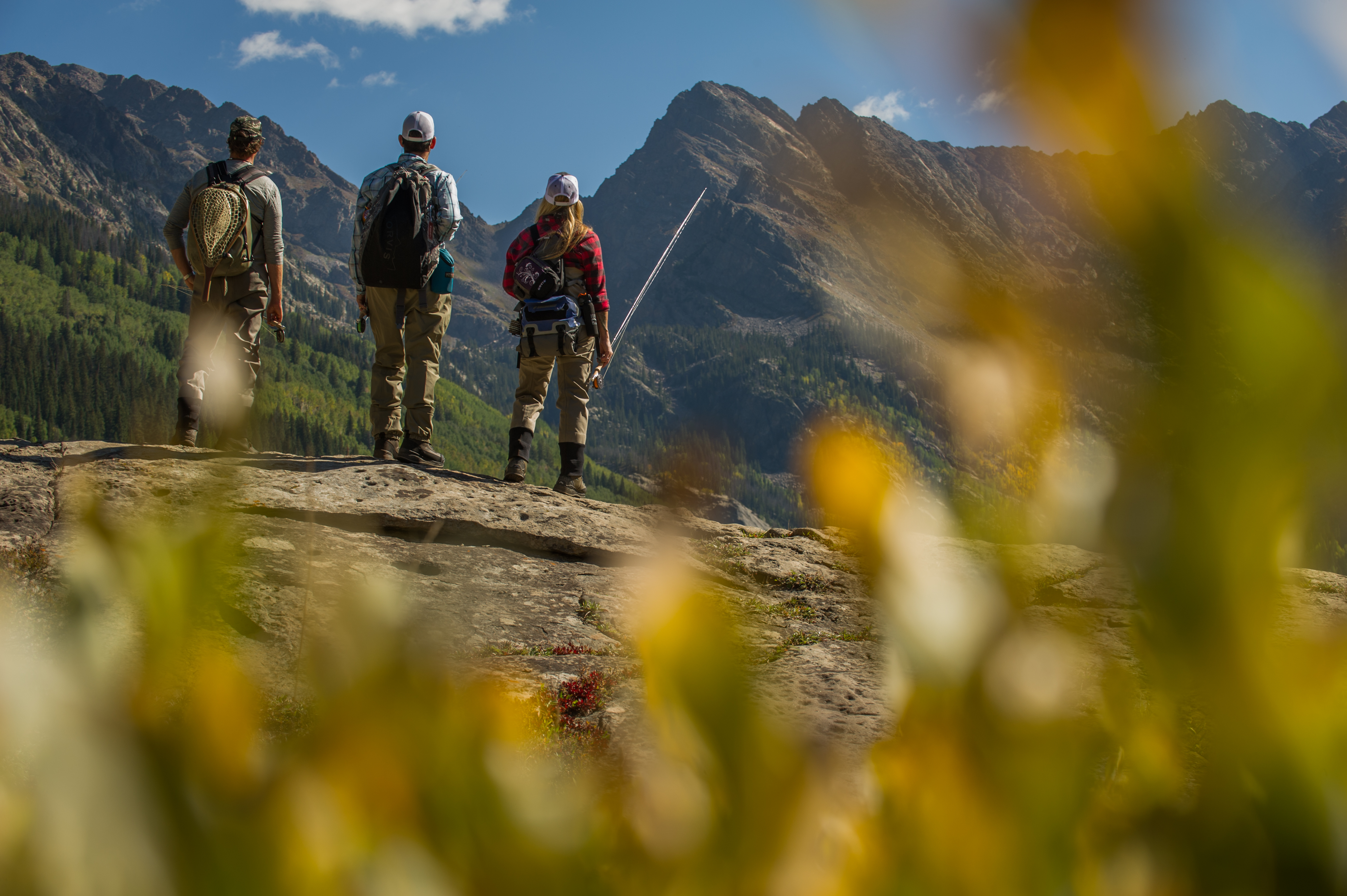 friends hiking in the mountains to go fly fishing