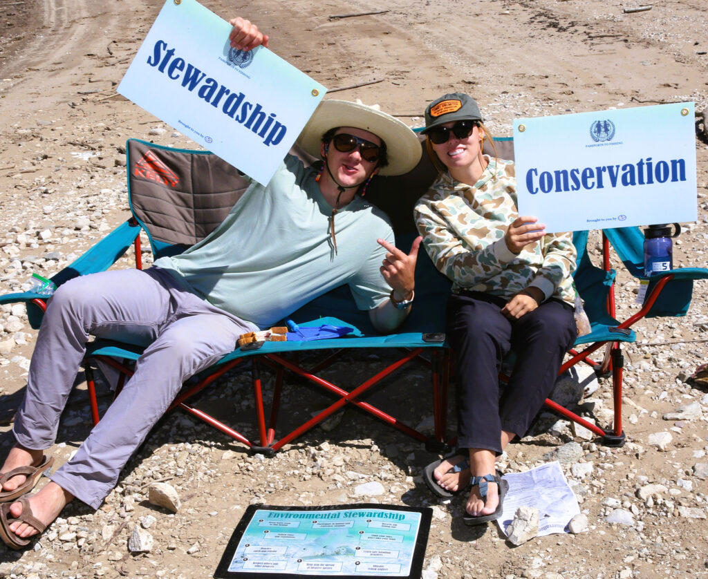 two college anglers holding convservation and stewardship signs at the Costa 5 Rivers Ambassador Summit
