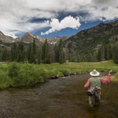 fishing a river mountains in the background with no snow