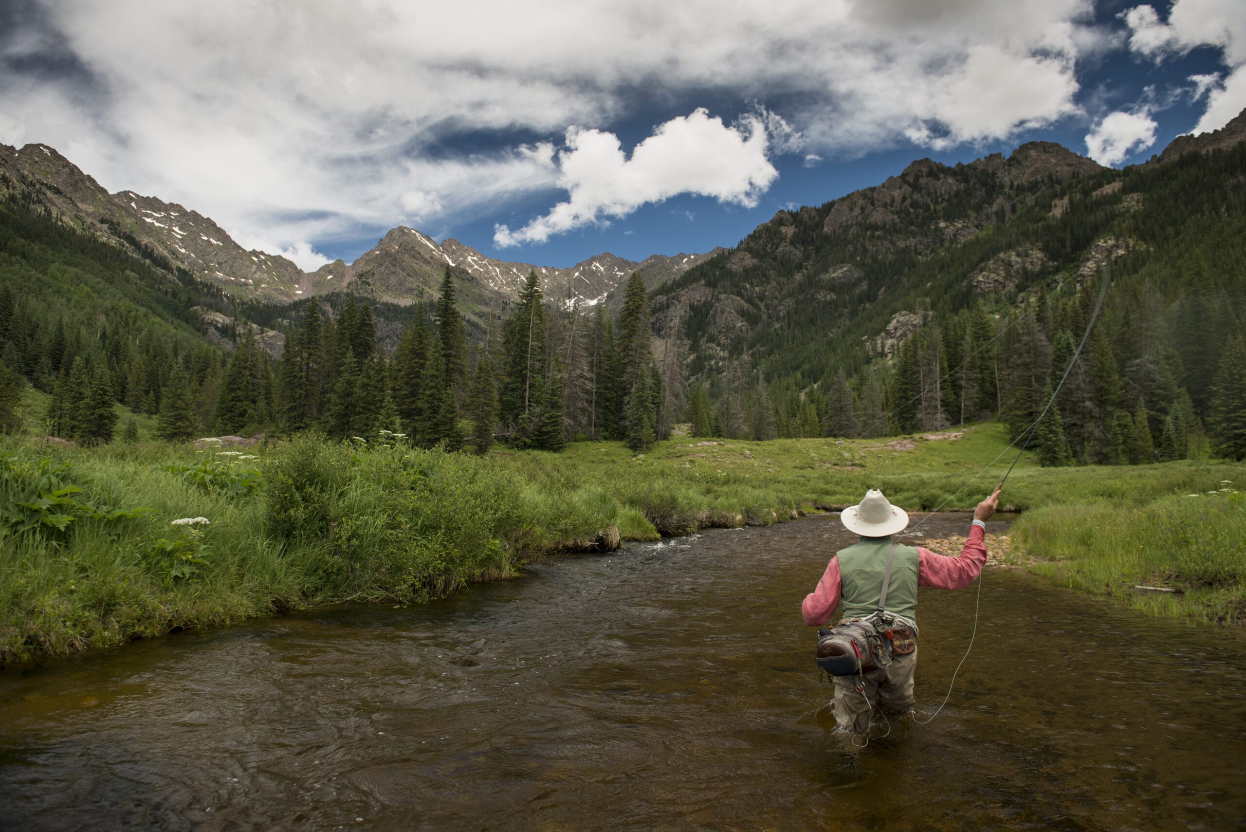 fishing a river mountains in the background with no snow