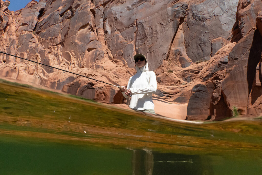 female angle standing clear water sandstone cliffs of grand canyon national monument in background