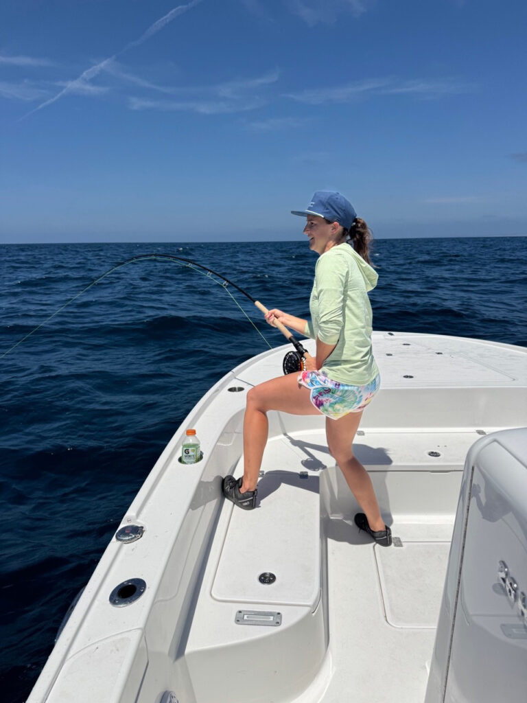 cathy holding fly rod with mako hooked up for the fight