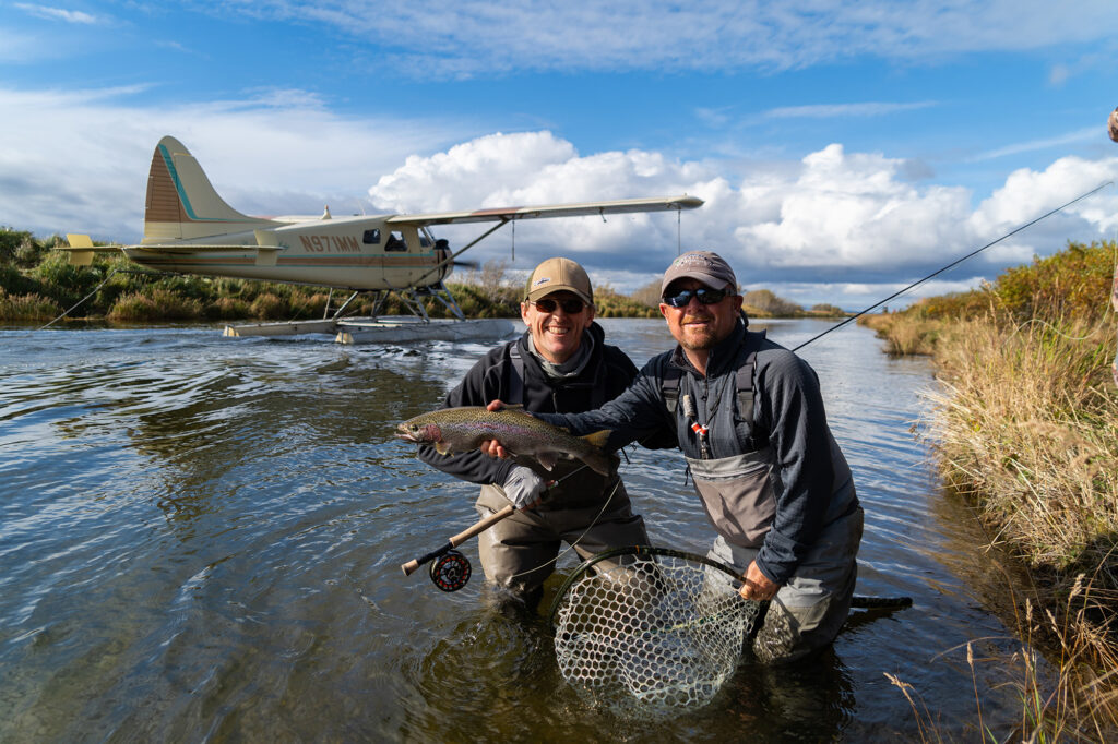 alaska fly out two anglers grip and grin holding rainbow trout